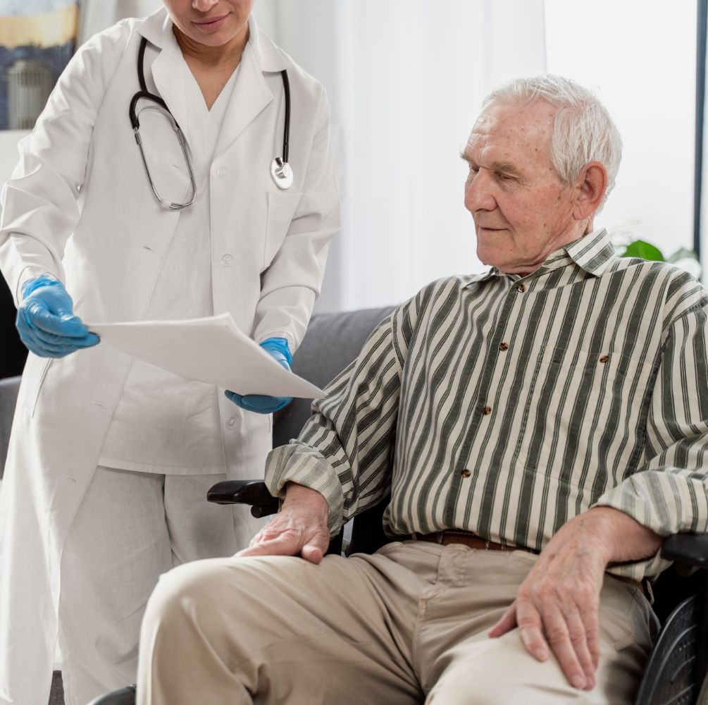 Persona mayor sentada junto a una doctora que le enseña examenes