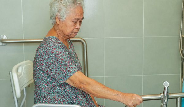 Persona-mayor-en-silla-de-baño-y-elementos-de-seguridad