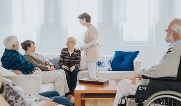 head-nurse-is-talking-to-new-patients-sitting-on-the-sofa-in-retirement-home