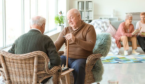 Adultos mayores jugando ajedrez en un hogar